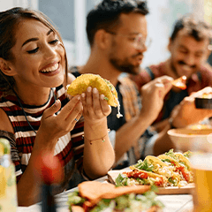 Woman smiling while eating lunch with friends at restaurant