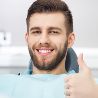 Thumbs up from a man in dentist’s chair