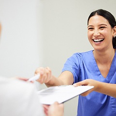 Dental team member helping patient